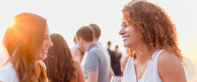 Female alumni conversing at sunset